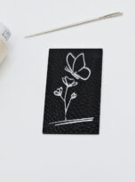 Kunstlederlabel Schmetterling auf Blume